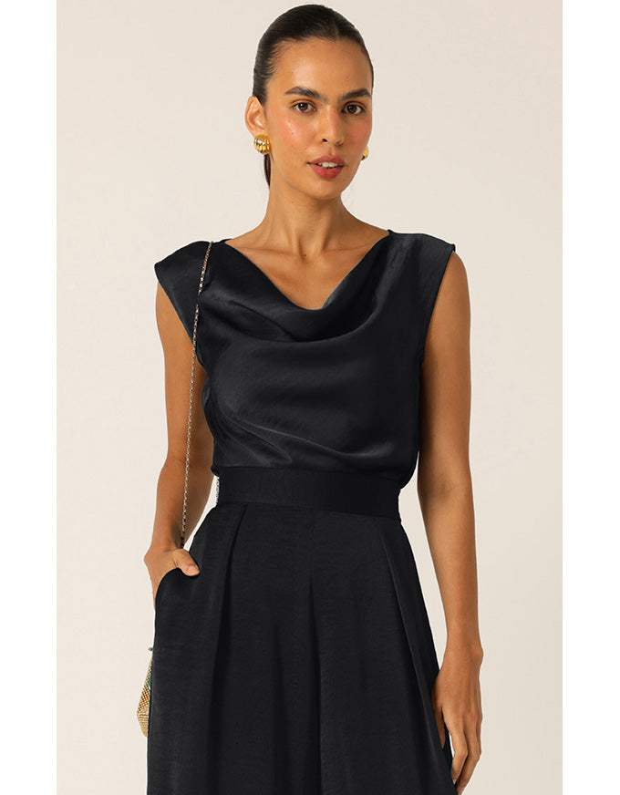 Woman wearing a black dress against a plain background