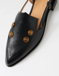 Black pointed-toe shoe with gold embellishments on a white background