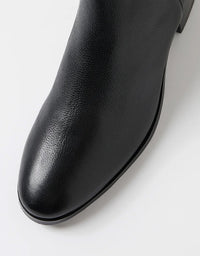 Close-up of a black leather ankle boot on a white background