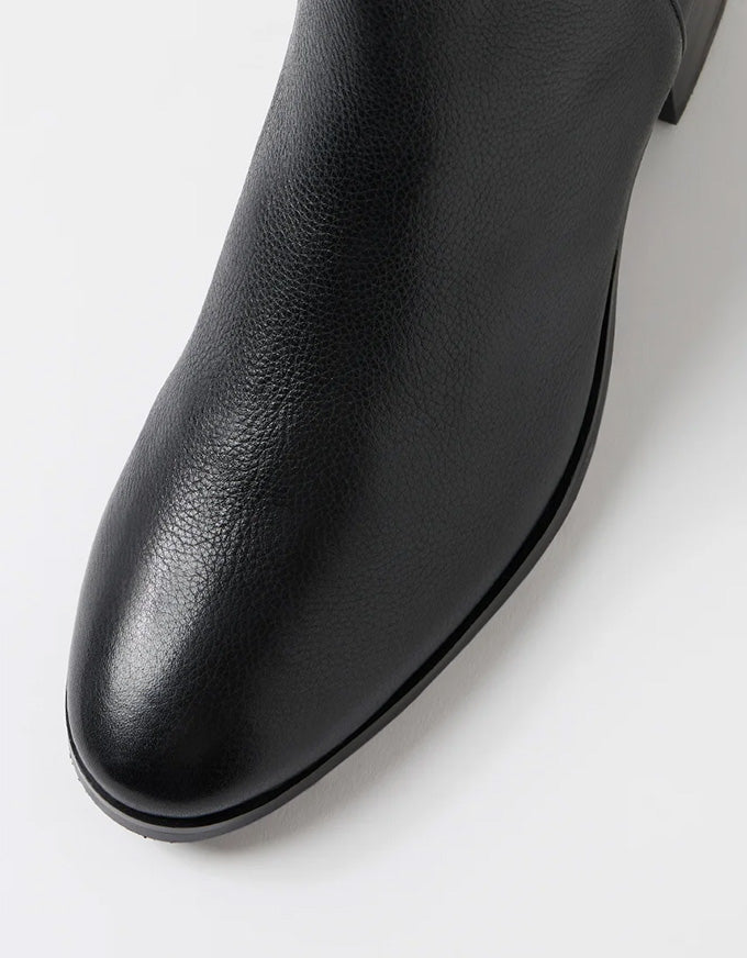 Close-up of a black leather ankle boot on a white background