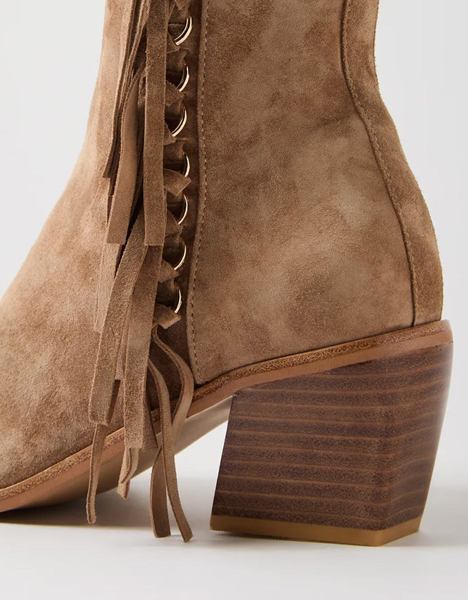 Brown suede boot with frayed laces on a white background