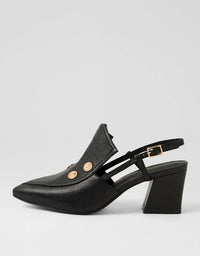Black heeled shoe with gold buttons on a light gray background