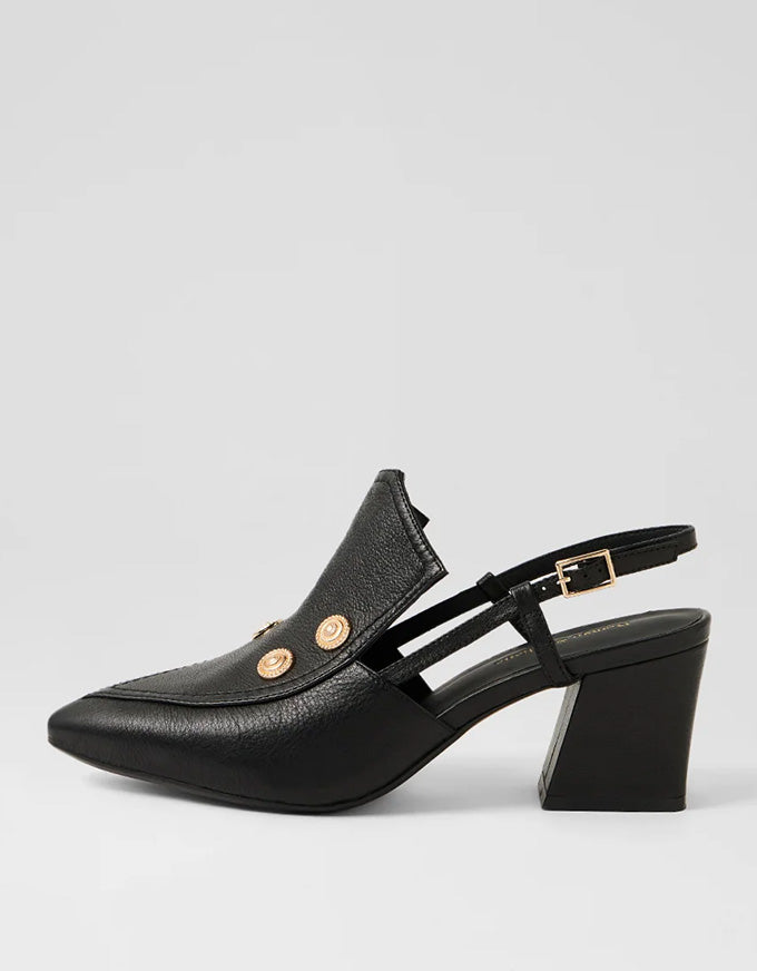 Black heeled shoe with gold buttons on a light gray background