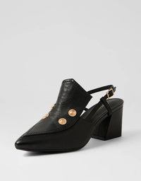 Black leather shoe with gold buttons on a light gray background