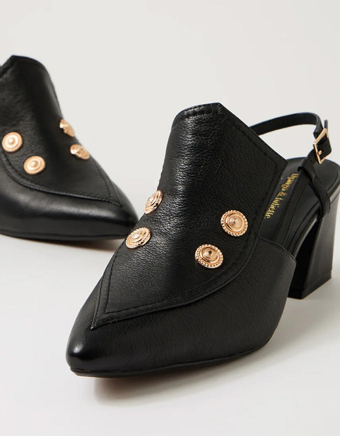 Black high-heeled shoes with gold embellishments on a light gray background
