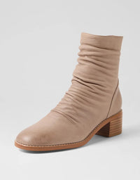 Beige ankle boot with a wooden heel on a light gray background