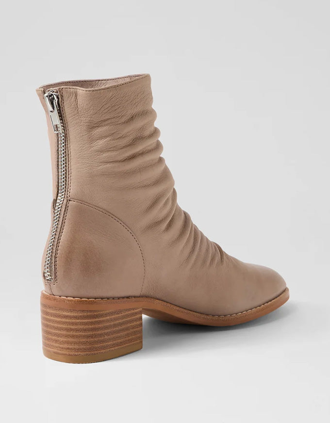 Beige ankle boot with a zipper on a light gray background