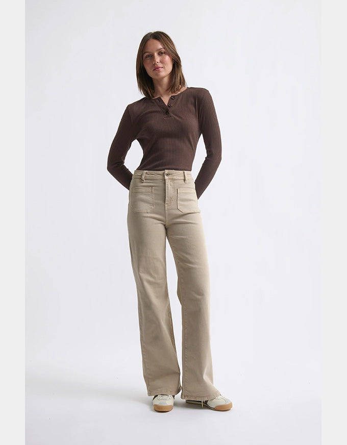 Woman wearing a brown top and beige pants on a white background