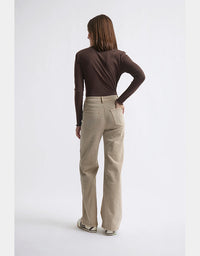 Person wearing beige pants and a brown top on a white background