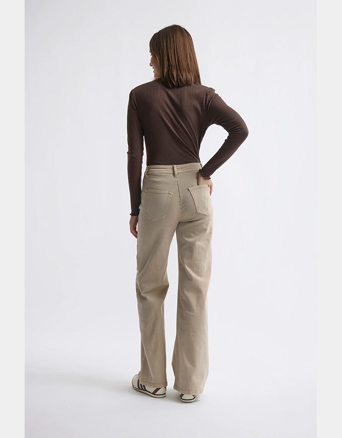 Person wearing beige pants and a brown top on a white background