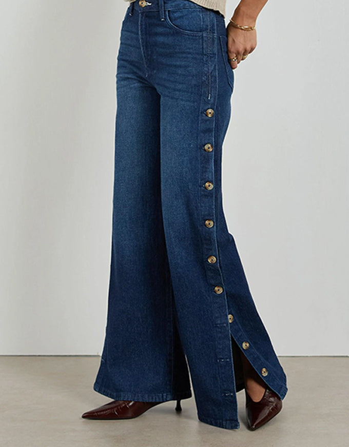 Blue wide-leg jeans with button details on a plain background