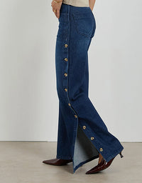 Blue denim pants with button details on a plain background