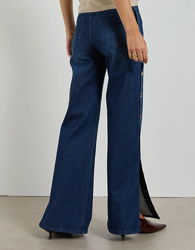 Person wearing blue flared jeans on a plain background