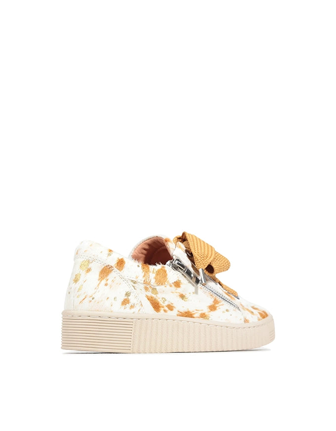 Sneaker with floral pattern and brown accents on a white background