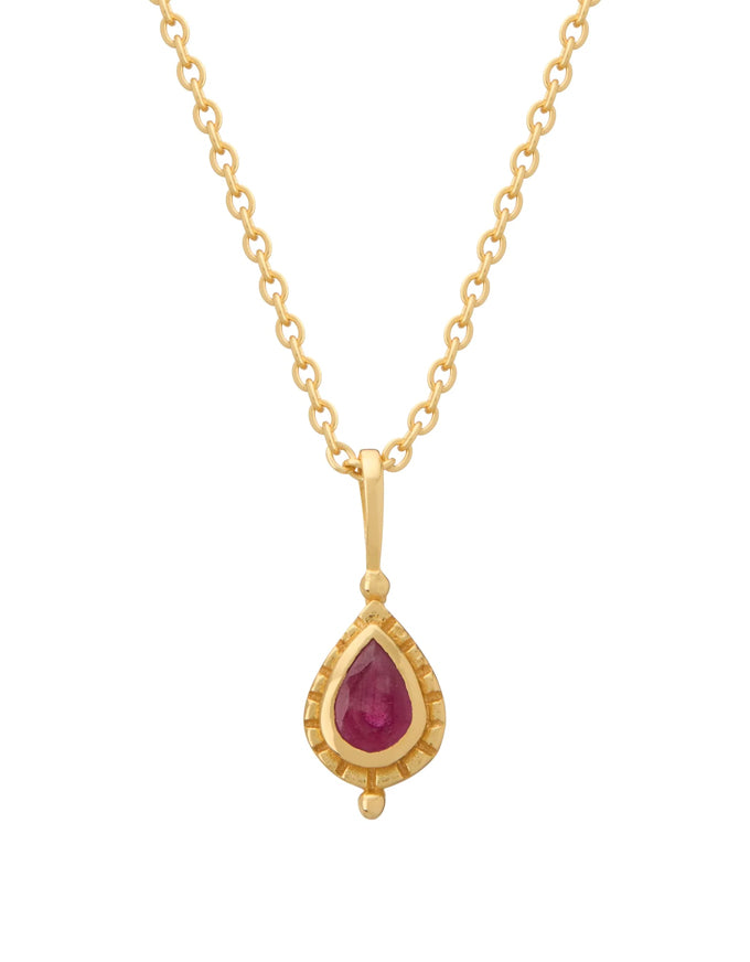 Gold necklace with a teardrop-shaped ruby pendant on a white background