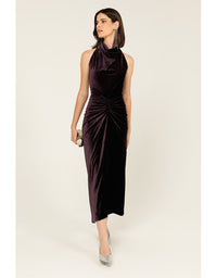 Woman wearing a dark purple halter neck dress on a white background