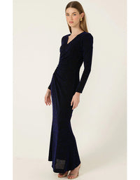 Woman wearing a long navy dress against a white background
