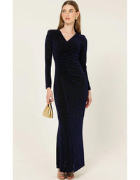 Woman wearing a long navy dress holding a gold clutch against a white background