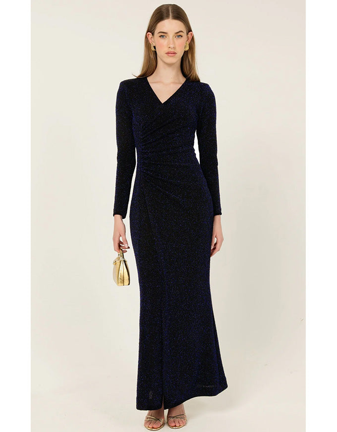 Woman wearing a long navy dress with long sleeves on a white background