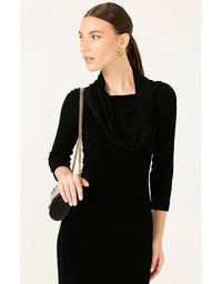 Woman wearing a black dress with a draped neckline against a white background