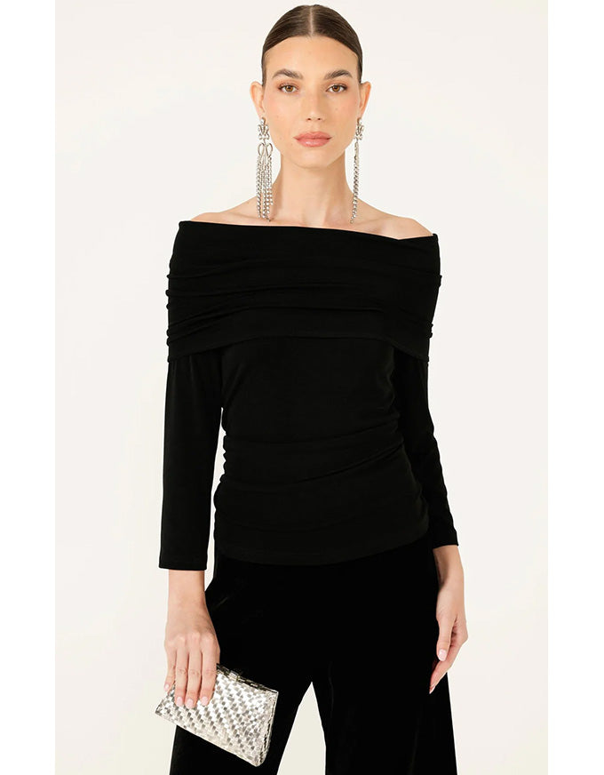 Woman wearing a black off-shoulder top and black pants with a white background