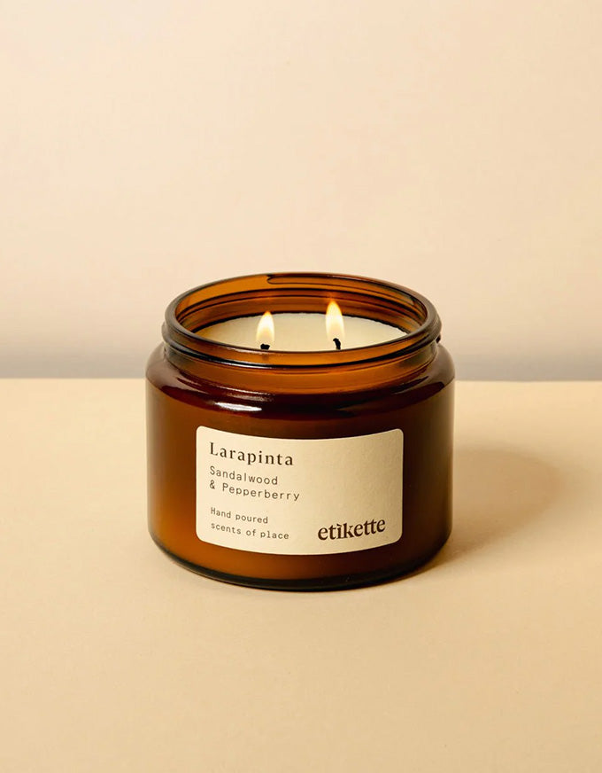 Larapinta candle in an amber jar with a beige background