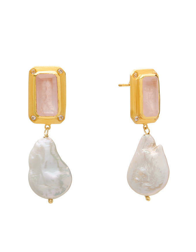 Gold earrings with pink gemstones and pearl-like drops on a white background
