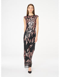 A woman modeling a sleeveless, floor-length black dress with a large pink and gray floral pattern, photographed against a plain white studio background.