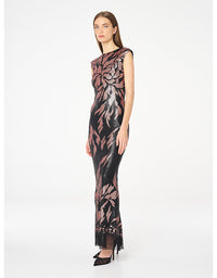 A model wearing a sleeveless, floor-length black dress with a metallic rose gold floral pattern, standing against a plain white studio background.