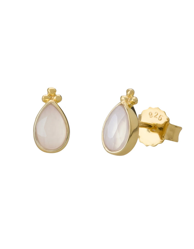 Gold earrings with teardrop-shaped white stones on a white background