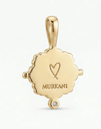 Gold pendant with 'MURKANI' engraving on a white background