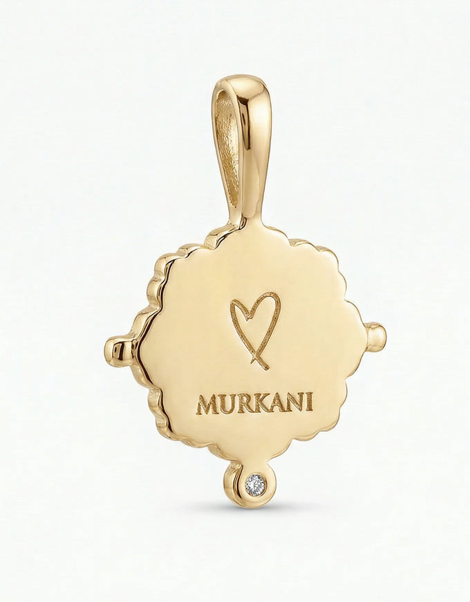 Gold pendant with 'MURKANI' engraving on a white background