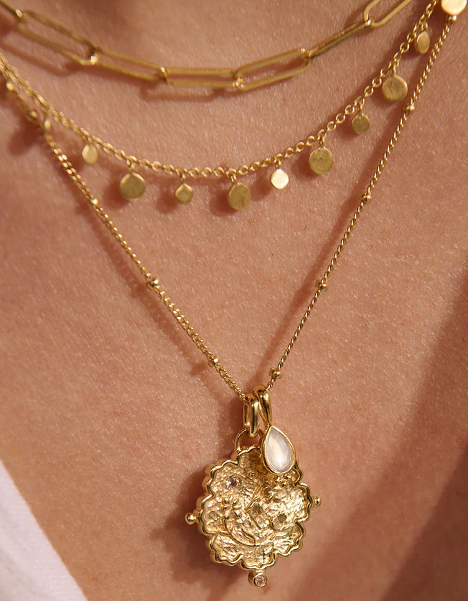 Gold necklace with a pendant on a skin background