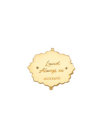 Gold pendant with engraved text on a white background