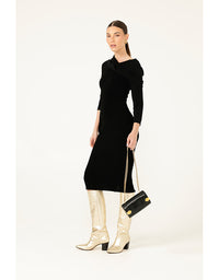 Woman wearing a black dress with long sleeves and a white background