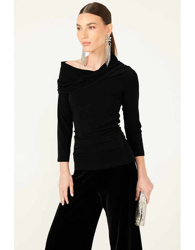 Woman wearing a black outfit with a draped top on a white background