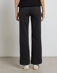 Person wearing black wide-leg pants against a plain background