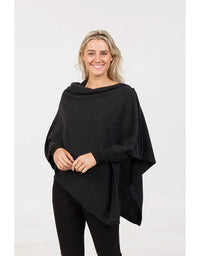 Woman wearing a black poncho against a white background