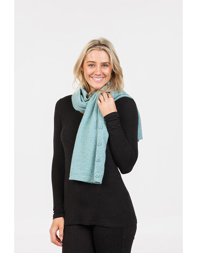 Woman wearing a light blue scarf against a white background