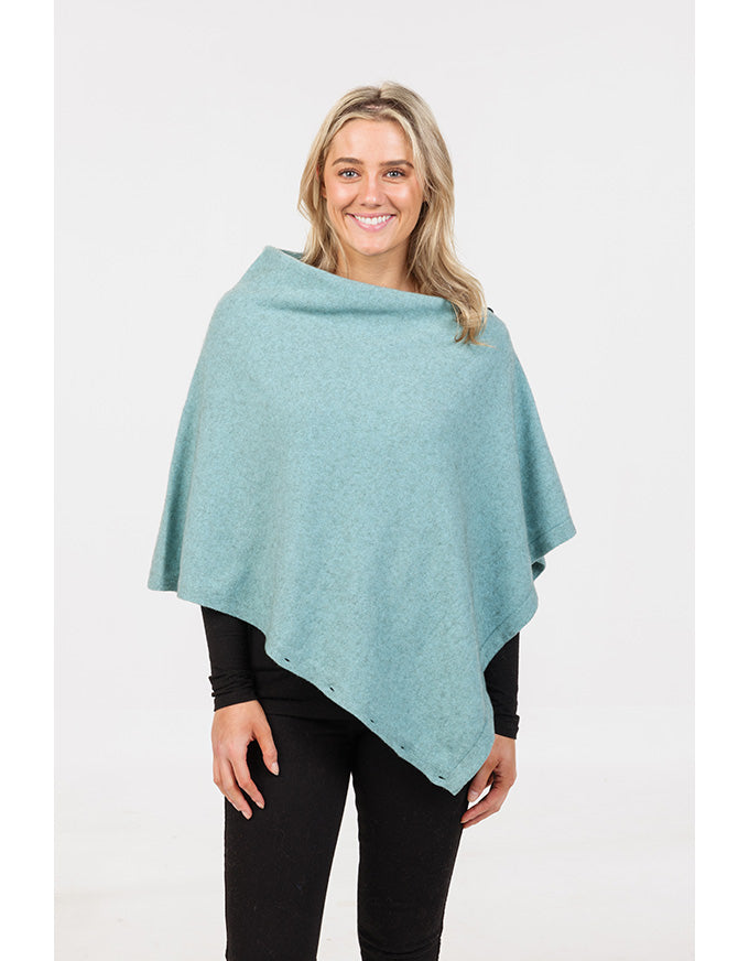 Woman wearing a light blue poncho on a white background