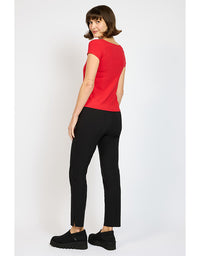 Woman wearing a red top and black pants on a white background