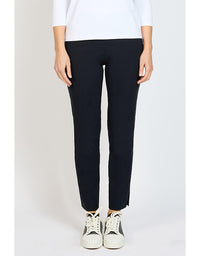Person wearing dark navy pants and white sneakers on a plain background