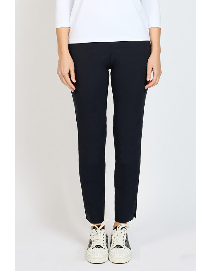 Person wearing dark navy pants and white sneakers on a plain background