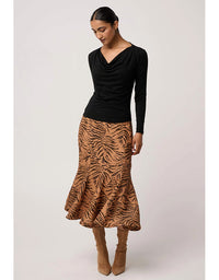 Woman wearing a black top and tiger print skirt on a white background