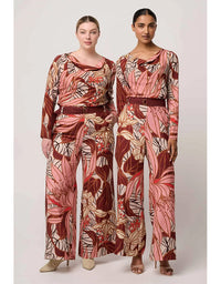 Two women wearing matching floral-patterned outfits on a plain background