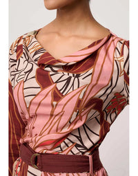 Patterned top with a belt on a plain background