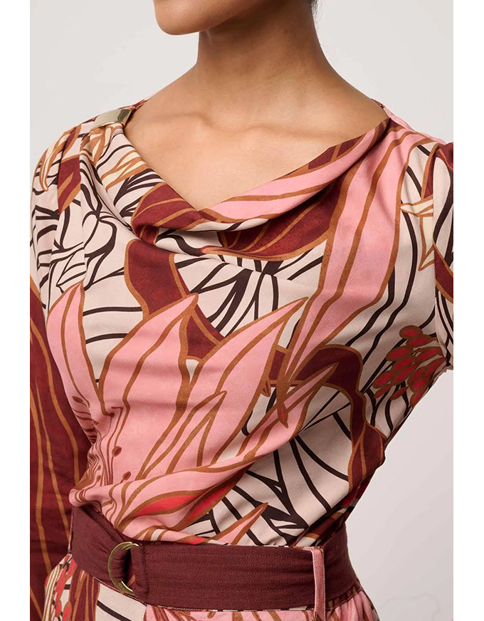 Patterned top with a belt on a plain background