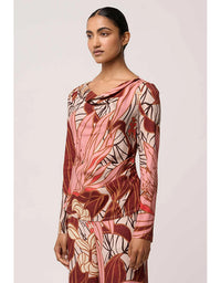 Woman wearing a long-sleeve dress with a floral pattern on a light pink background