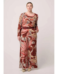 Woman wearing a long-sleeve floral dress with a belt on a white background