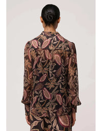 Person wearing a patterned shirt with a plain background